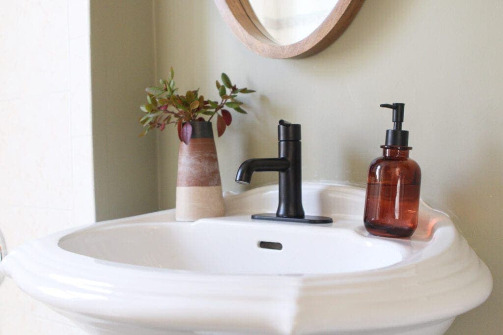 Pedestal sink and black faucet