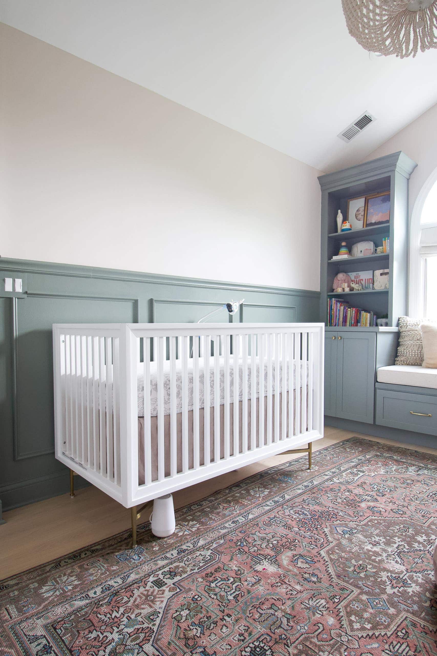 White crib in a sage and blush nursery