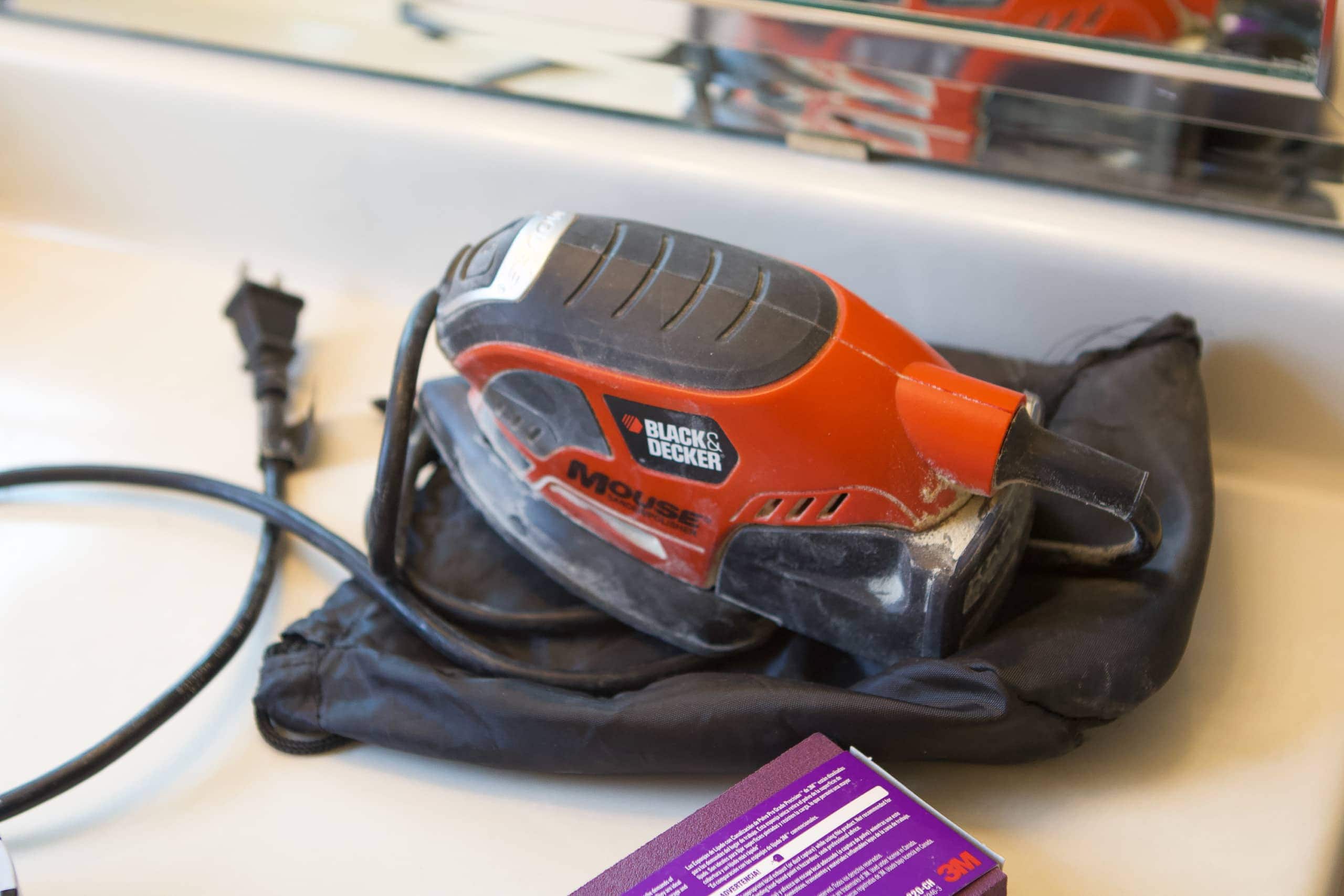 Use a palm sander to sand the cabinets