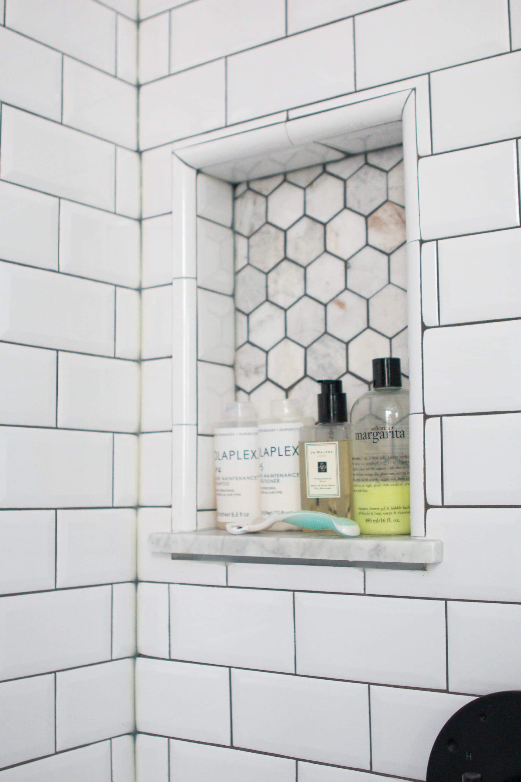 Shower niche in a marble and white bathroom