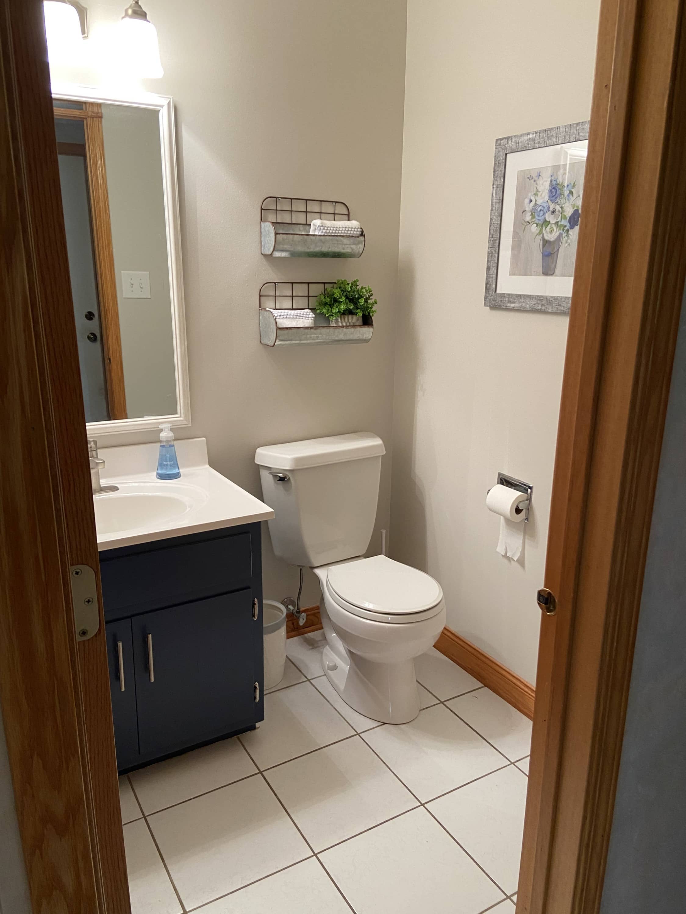 An updated bathroom with a blue navy painted vanity