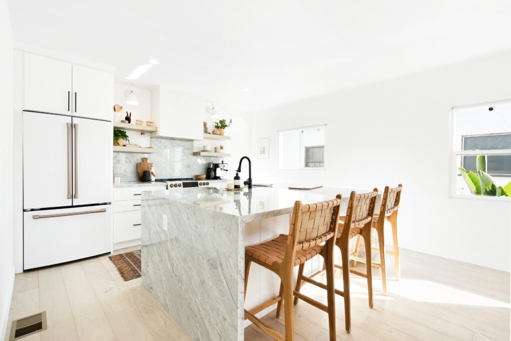 A modern kitchen with a marble waterfall countertop