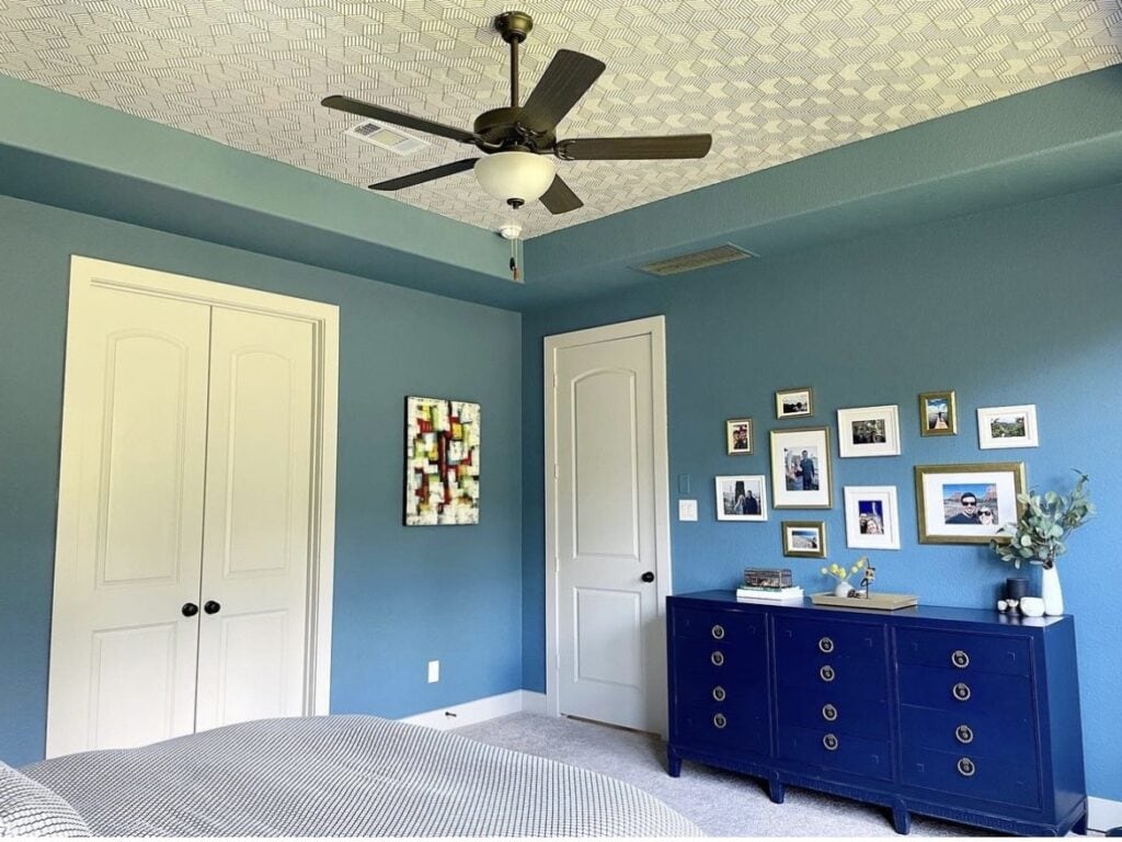 A blue bedroom with a bright blue dresser