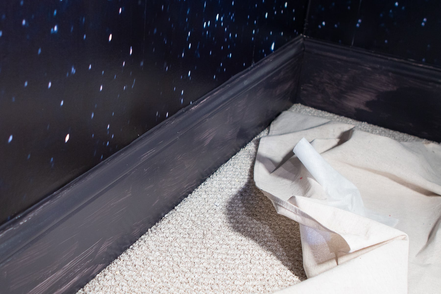A splotchy navy baseboard after one coat of paint