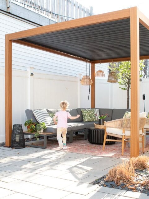 An outdoor space underneath a small backyard pergola
