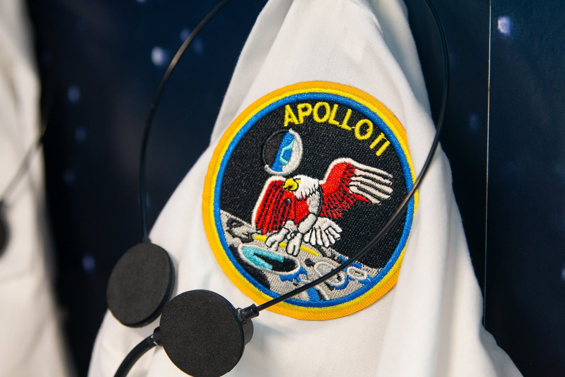 A headset and apollo patch on a lab coat